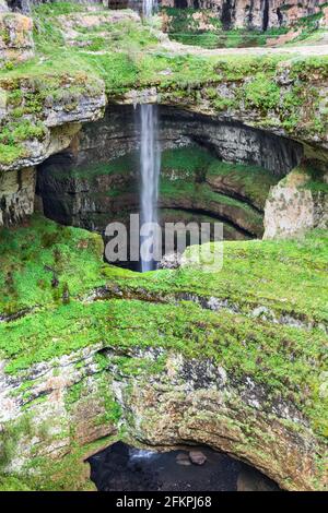 Wasserfall hinter einer natürlichen Brücke mit üppiger grüner Vegetation, Wasserfall in der Baatara-Schlucht, Libanon Stockfoto