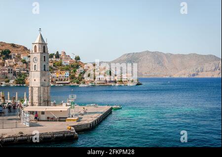 Der Uhrenturm und der Eingang zum Hafen von Symi, einer winzigen Insel der Dodekanes, in Griechenland. Stockfoto