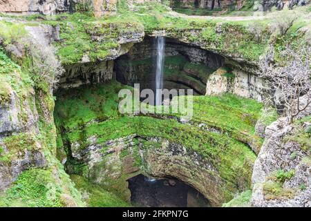 Wasserfall hinter einer natürlichen Brücke mit üppiger grüner Vegetation, Wasserfall in der Baatara-Schlucht, Libanon Stockfoto