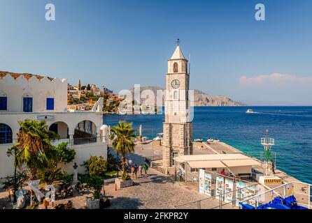 Der Uhrturm und die Einfahrt in den Hafen von Symi (Simi), eine kleine Insel der Dodekanes in Griechenland. Stockfoto