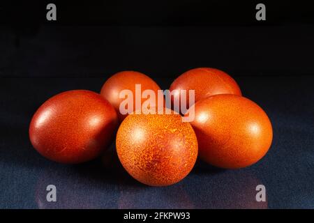 Bemalte Hühnereier auf dem Tisch mit einer Spiegelung. Essen auf schwarzem Hintergrund Stockfoto