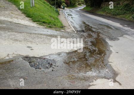 Natürliche unterirdische Quelle flutet in die Straße schaffen Schlaglöcher und Fließt den Hügel hinunter in Southend Garsington Oxford Stockfoto