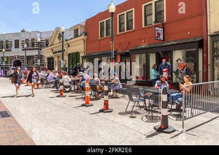 ASHEVILLE, NC, USA-1. MAI 2021: Geschäftiges Essen auf der Straße vor der frühen Girl Eatery an der Wall Street, an einem sonnigen Frühlingstag. Menschen. Stockfoto