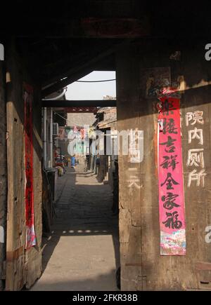 Pingyao in der Provinz Shanxi, China: Blick durch eine Tür mit chinesischer Schrift. Stockfoto