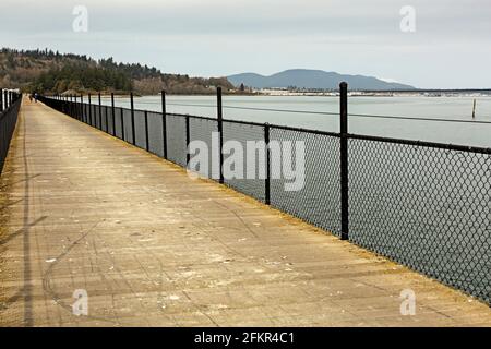 WA19569-00...WASHINGTON - der Böll, der Fidalgo Bay auf dem Tommy Thompson Trail überquert, mit dem Yachthafen und der Innenstadt von Anacortes im Hintergrund. Stockfoto