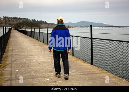 WA19571-00...WASHINGTON - Wanderer über den Tresle über Fidalgo Bay Der Tommy Thompson Trail mit dem Yachthafen und der Innenstadt von Anacortes In der BA Stockfoto