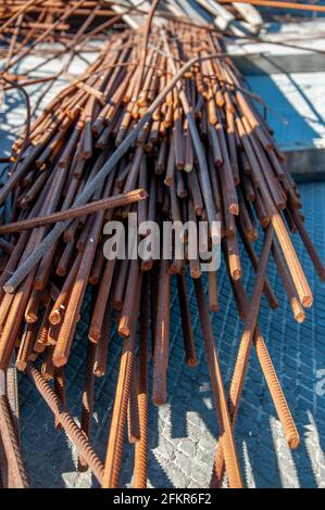 Nahaufnahme von rostigen Metallstäben. Haufen unebener Metallstäbe, die mit Rost bedeckt sind. Stapel von Eisenzweigen. Armatur aus alter Eisenkonstruktion aus nächster Nähe. Konstruktion m Stockfoto