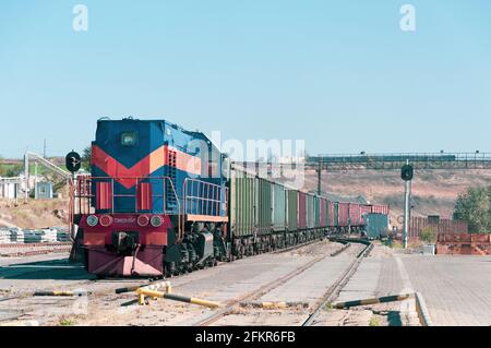 Lokomotive mit Containerzug auf Eisenbahngleisen im industriellen Güterumschlaggebiet. Die Nummer auf der Vorderseite der Lok enthält Buchstaben und Zahlen TEM2U 8517 Stockfoto