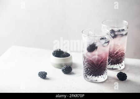 Erfrischende Blackberry Lemonade mit Eis in Kristallgläsern auf weißem Hintergrund Stockfoto