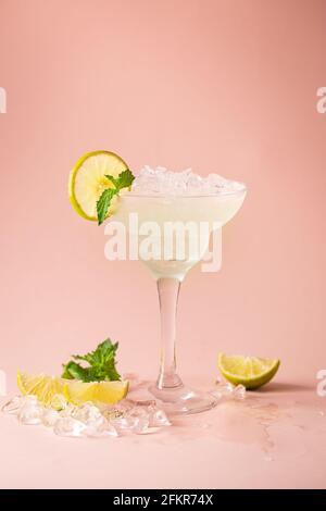 Cocktail margarita garniert mit Limette und Minze auf rosa Hintergrund Stockfoto