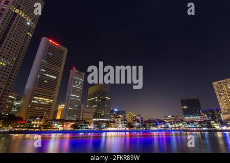 Clark Quay, Singapur - 03. Januar 2015: Spuren der Lichter am Flussufer des Singapore River und Bürogebäude am Flussufer. Stockfoto