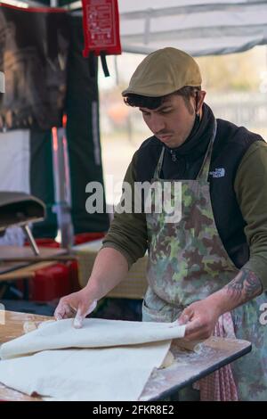 Mann legt eine Decke über Pizzakeigbällchen Stockfoto