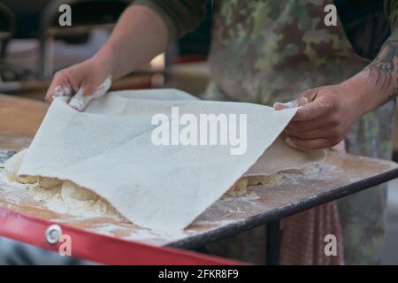 Mann legt Deckel über Teigkugeln draußen in einem Essen Markt Stockfoto