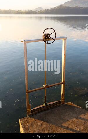 Vertikal ansteigendes Schleusentor, gesteuert durch ein metallisches Speichenrad, das den Wasserstand regelt Seve Ballesteros Santander Airport Cantabria Spanien Stockfoto