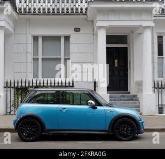 London, Greater London, England - Apr 27 2021: Blue Mini parkte vor einem Wohneigentum mit Geländern. Stockfoto