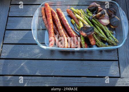 Nahaufnahme von gegrillten Speisen im Glasbehälter auf dunklem Holztisch. Schweden. Stockfoto