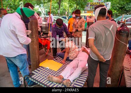 Ghaziabad, Indien. Mai 2021. Eine Gesundheitshelferin betreut eine junge Covid-19-Patientin, die Schwierigkeiten beim Atmen hat, indem sie mit Hilfe einer Sauerstoffmaske außerhalb von Gurudwara Sri Guru Singh Sabha atmet.Indien steht vor einem Mangel an medizinischem Sauerstoff. Unter solchen Umständen hilft eine NGO namens Khalsa Help International Covid-19-Patienten, indem sie ihnen freien Sauerstoff anbietet. In den letzten 24 Stunden verzeichnete Indien 3 68,147 neue Covid19-Fälle mit 3417 Todesfällen. Kredit: SOPA Images Limited/Alamy Live Nachrichten Stockfoto