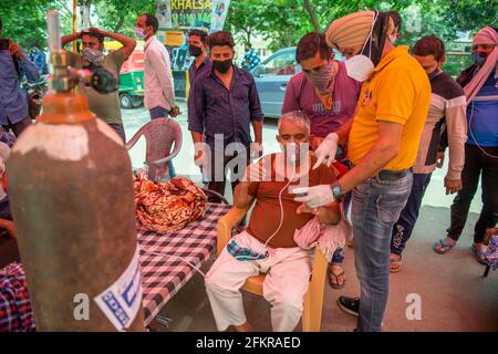 Ghaziabad, Indien. Mai 2021. Ein Gesundheitsbeamter liest den Sauerstoffgehalt von Covid-19-Patienten während des freien Sauerstoffs Langar außerhalb von Gurudwara Sri Guru Singh Sabha. Indien steht vor einem Mangel an medizinischem Sauerstoff. Unter solchen Umständen hilft eine NGO namens Khalsa Help International Covid-19-Patienten, indem sie ihnen freien Sauerstoff anbietet. In den letzten 24 Stunden verzeichnete Indien 3 68,147 neue Covid19-Fälle mit 3417 Todesfällen. Kredit: SOPA Images Limited/Alamy Live Nachrichten Stockfoto