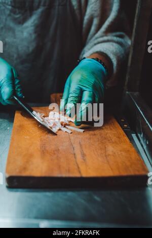 Person, die das Fleisch für die Herstellung von Burgern schneidet Stockfoto
