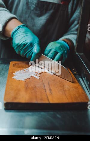 Person, die das Fleisch für die Herstellung von Burgern schneidet Stockfoto