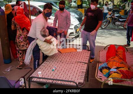 Ghaziabad, Indien. Mai 2021. Ein Verwandter trägt einen Covid-19-Patienten, der Schwierigkeiten beim Atmen hat, um Sauerstoff außerhalb von Gurudwara Sri Guru Singh Sabha Indirapuram zu erhalten.Indien steht vor einem Mangel an medizinischem Sauerstoff. Unter solchen Umständen hilft eine NGO namens Khalsa Help International Covid-19-Patienten, indem sie ihnen freien Sauerstoff anbietet. In den letzten 24 Stunden verzeichnete Indien 3 68,147 neue Covid19-Fälle mit 3417 Todesfällen. (Foto von Pradeep Gaur/SOPA Images/Sipa USA) Quelle: SIPA USA/Alamy Live News Stockfoto