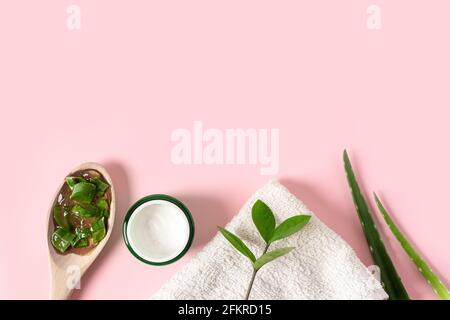 Draufsicht mit Aloe Vera Saft, Bio-Creme, Gel, Handtuch und grünen Blättern. Stockfoto