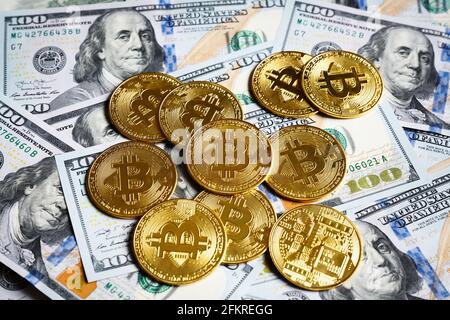 Bitcoin- und US-Dollar-Scheine, digitale Krypto-Währung Bitcoin und Banknoten. Stapel von Goldmünzen auf Dollarnoten Hintergrund. Konzept der virtuellen mon Stockfoto