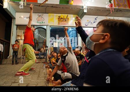 Iraqi Children interagieren mit einem italienischen Clown, der eine Unterhaltungsshow für sie vorführt.eine Unterhaltungsshow wird vom italienischen Clown Marco Rodari inszeniert, Bekannt als Claun il Pimpa für Kinder in der Hammam Al-Manqusha-Gegend in der Altstadt von Mossul, um ihnen zu helfen, mit den Auswirkungen des Krieges und der Besetzung der Stadt durch den IS (Islamischer Staat des Irak und Syrien) fertig zu werden. Die Show fand in dieser fröhlichen blauen Gasse statt, die vor kurzem von Jugendlichen Freiwilligen neu organisiert und arrangiert wurde, um eine wunderschöne Fassade des Gebiets zu werden, das sich nach der Zerstörung durch den letzten Krieg erholt hat. Stockfoto