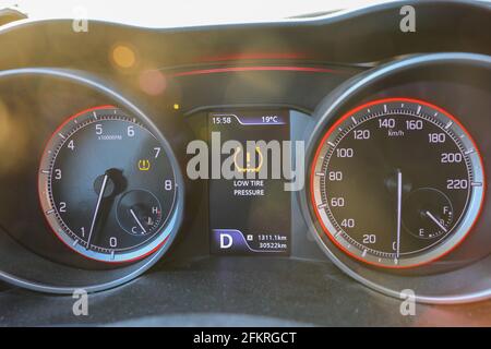 Fehlerzeichen für niedrigen Reifendruck. Warnleuchten blinken auf dem Armaturenbrett des Fahrzeugs. Stockfoto