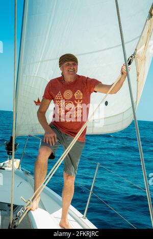 Ein Mann an Bord einer Segelyacht auf See. Yachting. Aktives Lifestyle-Konzept. Stockfoto