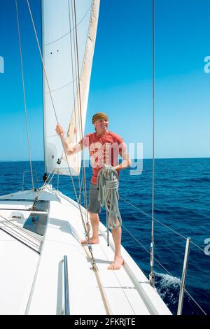 Ein Mann an Bord einer Segelyacht auf See. Yachting. Aktives Lifestyle-Konzept. Stockfoto