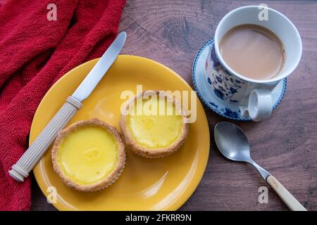 Eiertörtchen auf einem Tisch, serviert mit einer Tasse Tee. Stockfoto