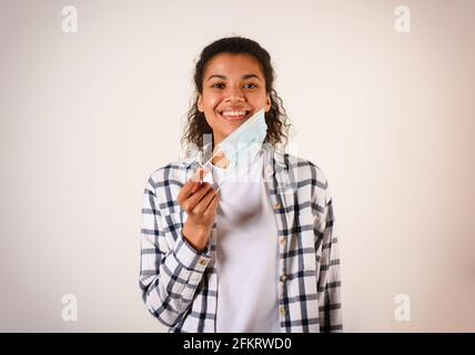 Frau entfernt die Gesichtsmaske. Konzept der Pandemie des Covid-19 Coronavirus Stockfoto