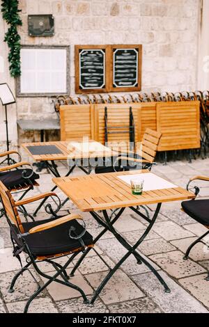Hölzerne Klapptische und geschmiedete Stühle eines Straßencafés in der Altstadt VON DUBROVNIK, KROATIEN. Stockfoto