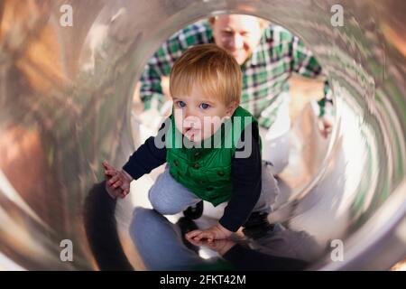 Junge klettert Folie auf Spielplatz Stockfoto