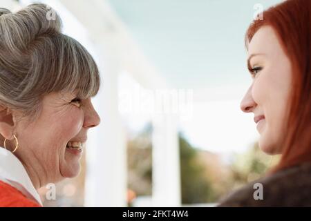 Nahaufnahme einer älteren Frau und einer erwachsenen Tochter, die auf der Veranda lachte Stockfoto