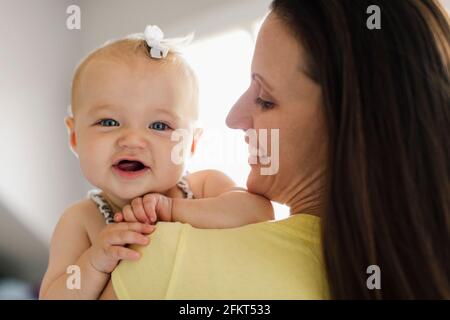 Über die Schulter im Hochformat glückliches Babymädchen und mid-adult Mutter Stockfoto