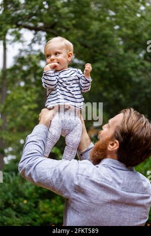 Vater hält Babymädchen in Luft, im freien Stockfoto