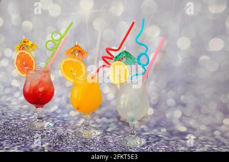 Drei große Gläser Zitrusfrüchte, dekoriert mit Scheiben Limette, Orange und Grapefruit auf grauem Hintergrund. Nahaufnahme. Stockfoto