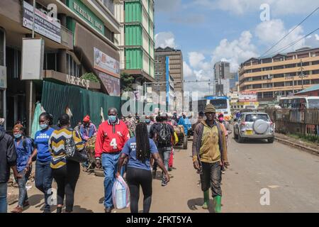 Die Bewohner von Nairobi gehen an belebten Straßen vorbei, nachdem die Regierung die Einstellung der Bewegung in und aus Nairobi zwischen den Bezirken aufgehoben hat. In seiner vollständigen Rede zum Labor Day sprach Präsident Uhuru Kenyatta am 1. Mai an die Nation aus dem Staatshaus. Die Begrenzung aller öffentlichen Verkehrsmittel und Reisen über die Landkreise hinweg wurde aufgehoben, da Schulen und Bildungseinrichtungen sich gemäß dem Akademischen Kalender des Bildungsministeriums auf die Wiedereröffnung am 10. Mai vorbereiten. Der Präsident erweiterte die landesweite Ausgangssperre auch über Nairobi, Machakos, Kajiado, Kiambu und Nakuru hinweg für einen Zeitraum von 30 Tagen täglich bis 10 Uhr bis 4 Uhr. Stockfoto