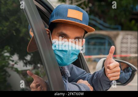 Menschen tragen Gesichtsmaske im Auto, Mann tragen medizinische Maske im Auto, Maske schützen covid19 Coronavirus Stockfoto