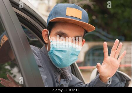 Menschen tragen Gesichtsmaske im Auto, Mann tragen medizinische Maske im Auto, Maske schützen covid19 Coronavirus Stockfoto