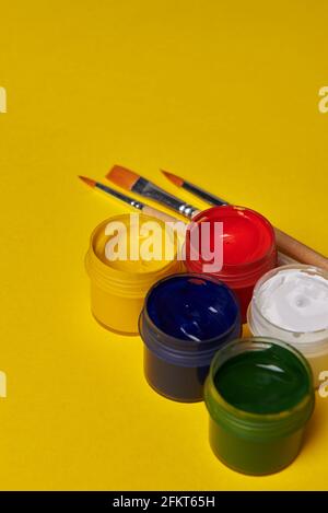 Farbige Farbgläser auf gelbem Hintergrund Stockfoto