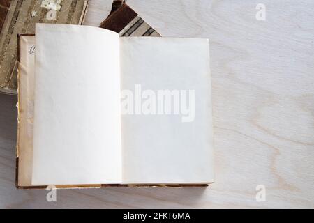 Altes Vintage-Buch auf Holztisch. Öffnen Sie das Buch mit leeren Seiten Stockfoto