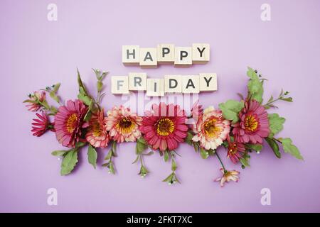 Happy Friday Buchstaben mit Blumendekoration von oben auf lila Hintergrund Stockfoto