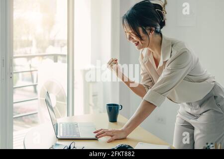 Begeisterte Asiatische Geschäftsfrau Feiert Erfolg Am Arbeitsplatz. Stockfoto