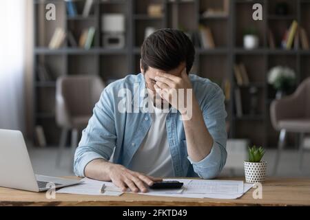 Unglücklicher Geschäftsmann mit Brille, der Rechnungen berechnet, besorgt über finanzielle Probleme Stockfoto