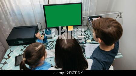 Mutter und Kinder, die auf den Computerbildschirm schauen Stockfoto