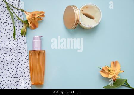 Beauty-Konzept mit kosmetischen Accessoires auf blauem Hintergrund. Kosmetische Flasche Mockup, Patches und Alstroemeria Blumen. Hochwertige Fotos Stockfoto