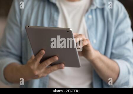 Nahaufnahme Mann hält Tablet, tippen auf dem Bildschirm, Apps durchsuchen Stockfoto